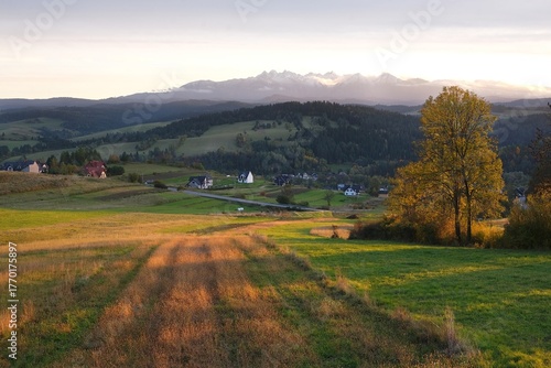 Beautiful scenery of snow-covered Tatras Mountains and village Sromowce Wyzne in autumn scenery in evening light, Poland