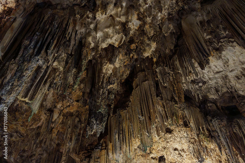 Karst Cave Ceiling with Vertical Stalactite Curtains and Rich Mineral Detail