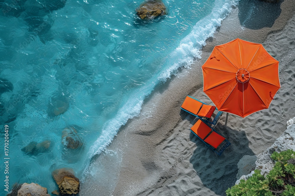 Naklejka premium Orange Umbrella And Chairs Near Ocean Rocks