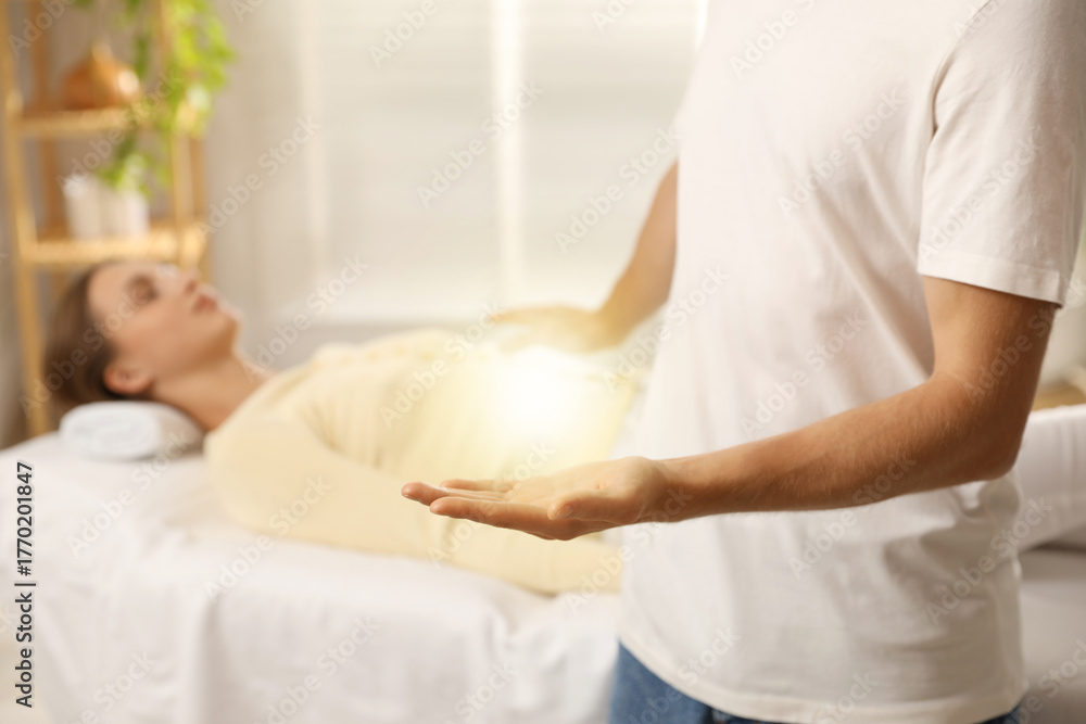 Obraz premium Reiki master showing his hand while healing patient's aura during therapy indoors, closeup