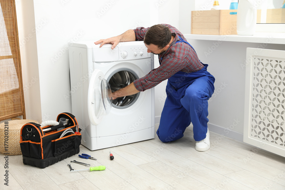 Obraz premium Professional repairman fixing broken washing machine indoors