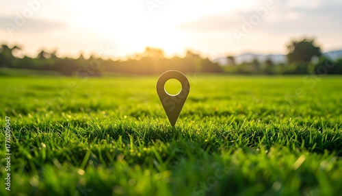 Location pin in green grass at sunset.