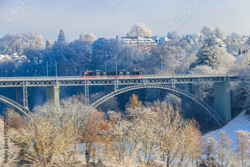 Wallpaper Mural View to the Kirchenfeld bridge with running red tram on winter snowy day in Bern, Switzerland Torontodigital.ca