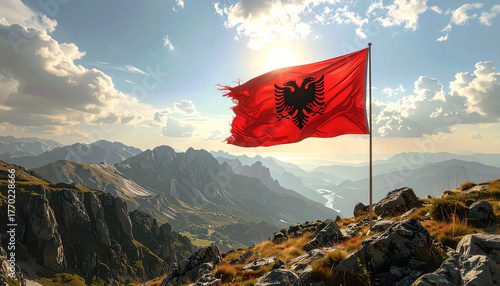 Albanian flag waving proudly atop rugged mountain peak, scenic panorama embodies national pride and adventurous spirit under bright sunlight