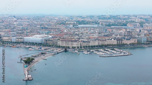 Aerial view of Bains des Pâquis, with its pier extending into the tranquil waters, and the city sprawling in the background, Geneva, Switzerland.