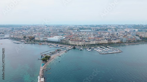 Aerial view of Bains des Pâquis, a pier extending into the tranquil waters, contrasting with the cityscape beyond, Geneva, Switzerland.