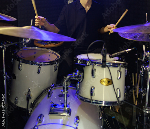 Drummer Playing on White Drum Kit