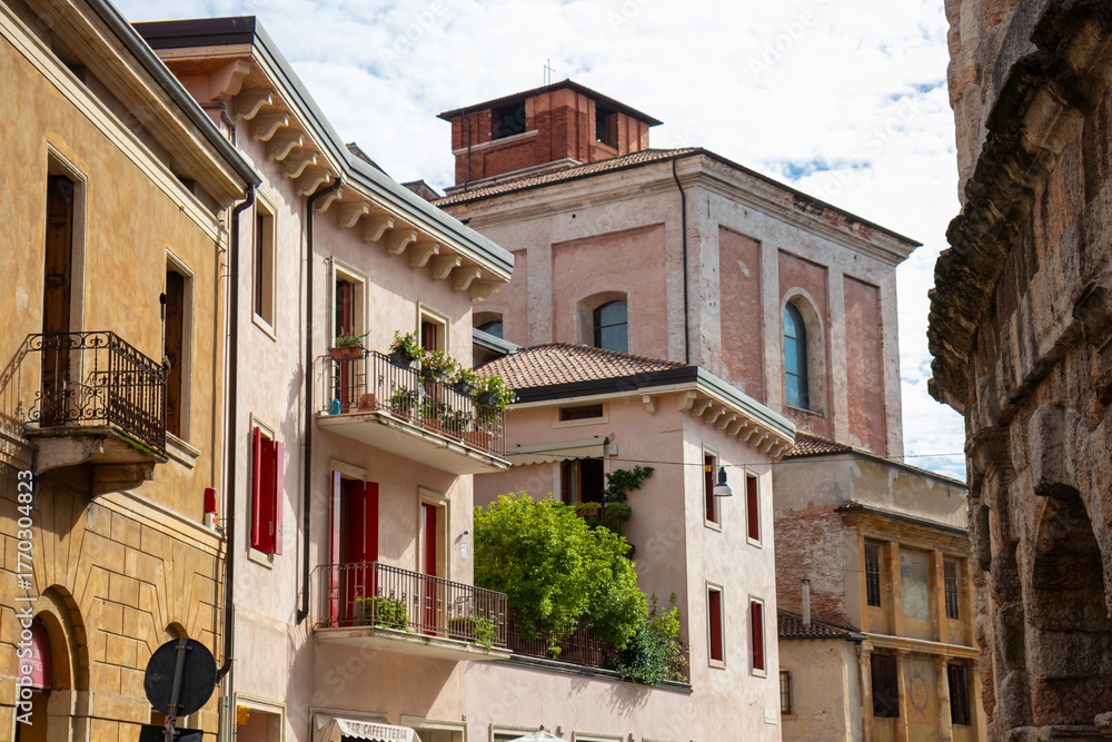 Obraz premium Streets of Verona, Italy - charming medieval lanes lined with colorful buildings, cobblestone paths, historic architecture, bustling cafes, and vibrant city life in the Veneto region