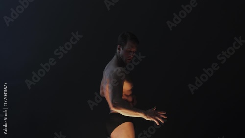 A muscular athlete in an epic pose, fog and smoke on the background, warm mystical light from below, the concept of the antique beauty of the human body