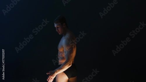Muscular athlete in epic pose with fog background, warm mystical lighting from below