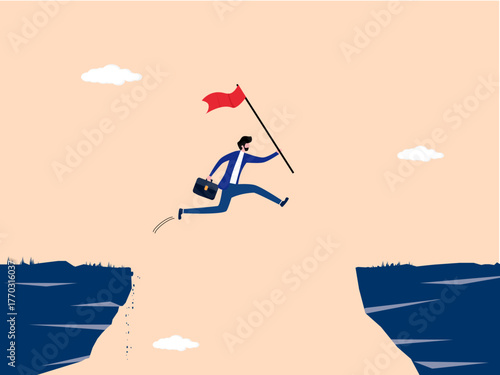 Businessman holding a flag jumps over a gap in the cliff