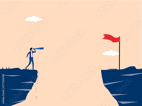 businessman looks across a gap in the cliff with a telescope at the new flagpole