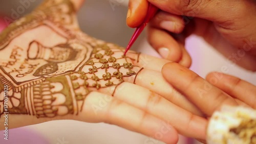Mehndi being applied on a woman’s hand as part of puja preparation for Indian festivals