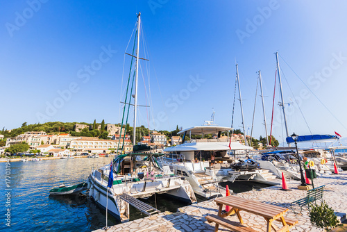 Peaceful marina with sailboats and catamarans on sunny day