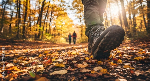 Fototapeta Naklejka Na Ścianę i Meble -  Autumn Forest Hike: Close-up of Boots on Trail with Couple in Background