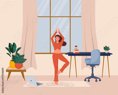 Woman practicing yoga tree pose at home with online class