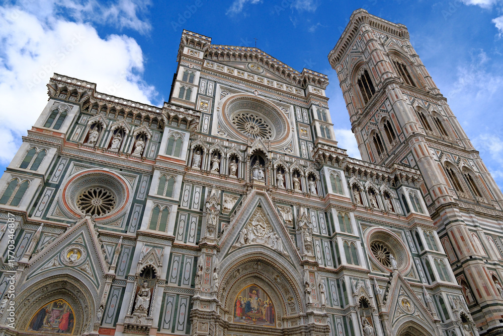 Fototapeta premium ornate marble facade of Florence Cathedral (Duomo di Firenze) and Giotto's Campanile in Italy. low angle view