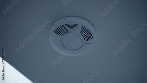 Modern Smart Smoke Detector on Ceiling Lights Up and Goes Off