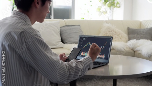 株価の上昇を見て喜ぶアジア人男性