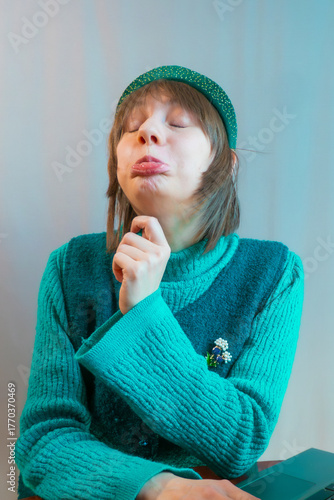 A beautiful young woman is working or playing or shopping on a laptop in a stylish modern dress and a hair band in the shape of the Russian national kokoshnik headdress