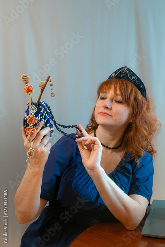 A beautiful young woman chooses jewelry in a stylish modern dress and a hairband in the shape of the Russian national kokoshnik headdress