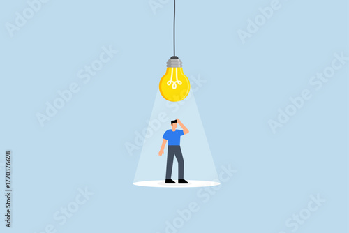 Innovation, clever entrepreneur pondering beneath creative illuminated light bulb.