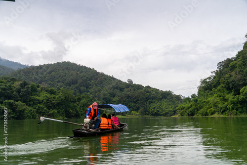A man is rowing a boat with a canopy on top