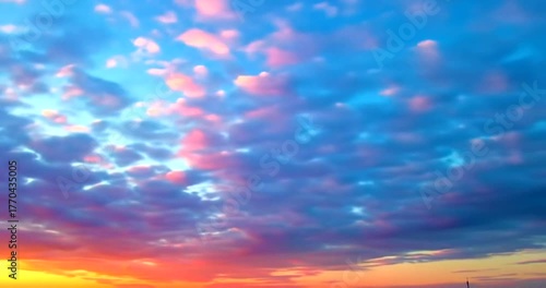 Sunset sky with scattered clouds painted in hues of orange, pink, purple, and blue, creating a beautiful atmospheric display.
