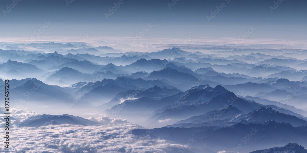 Fototapeta premium Layers of blue mountain ranges and peaks emerging through a serene fog from an aerial view