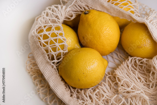 Fresh Lemons in Mesh Bag – Modern Lifestyle Concept on White Minimal Background