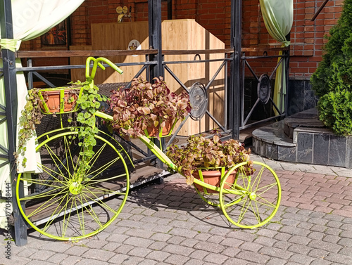 Autumn city decoration: a bicycle with flower baskets near a cafe