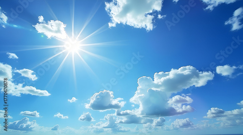 Bright sunburst illuminates fluffy clouds against a vibrant blue sky, evoking feelings of hope and boundless possibility for your next project.