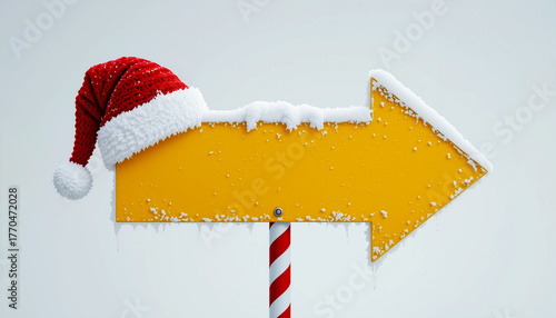 Yellow arrow sign with santa hat and snow for christmas direction