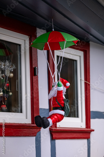 Santa Claus jumped with a parachute out of the window. Christmas miracles. New Year.