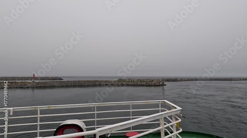 4K video showing a ferry sailing under the Norwegian flag waving in the wind above the deck.