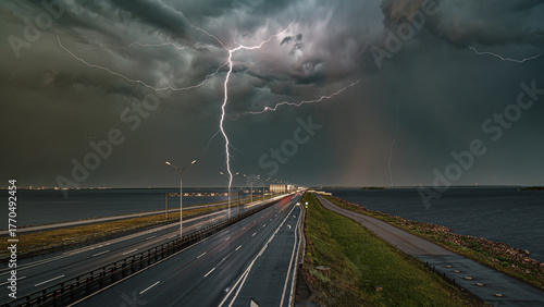 Fotografie Lightning strike over coastal highway during storm