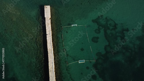 water polo field by the sea, by the concrete jetty, sunny day, summer, calm sea, view from a drone