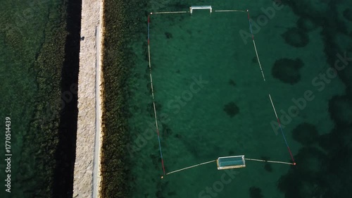 water polo field by the sea, by the concrete jetty, sunny day, summer, calm sea, view from a drone