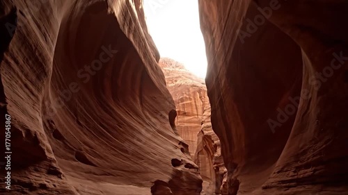 View through a sandstone slot canyon, light at the end
