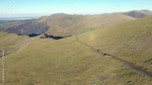 Aerial view of people hiking and climbing Snowdon mount in Wales on a sunny day