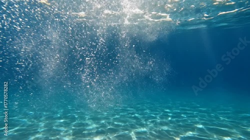 Sunbeams Pierce Through a Powerful Splash in a Serene CrystalClear Blue Ocean.