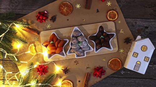 Dried fruits in a plate on a wooden table with festive decorations.