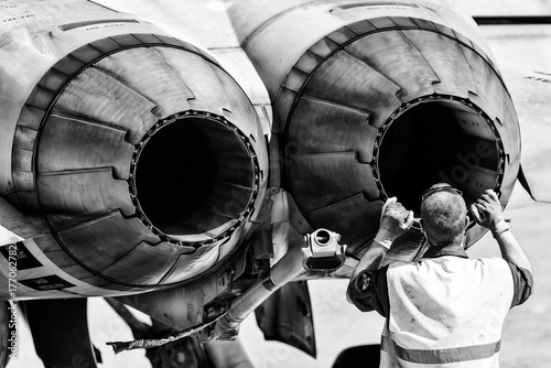 mechanic checking fighter engine