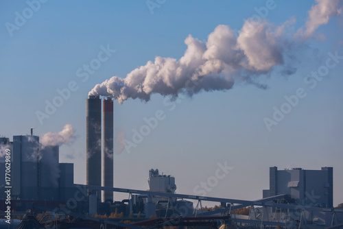 Smoke from the factory chimneys of a heating plant in the city. A power plant running on fuel oil or natural gas. Air pollution. Chimneys, ecology, heating season concept