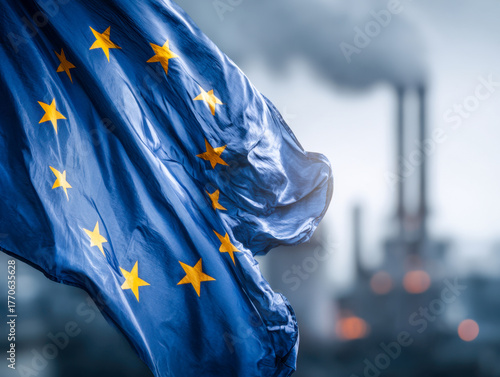 European Union flag waving in front of industrial chimneys emitting smoke symbolizing environmental challenges and pollution concerns within the region