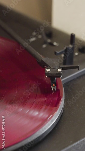 Red turntable disk vinyl record player close-up 4K footage. Vinyl record plays smoothly on a turntable in stunning vertical 4K video.