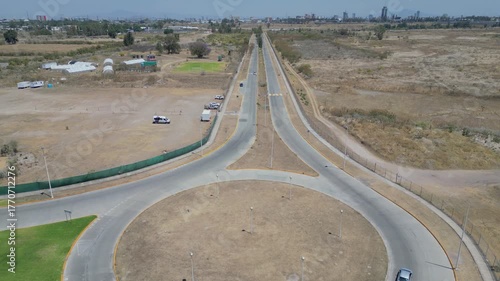 Aerial forward motion over road heading to Panamerican Villas surrounded by dry terrain and few cars
