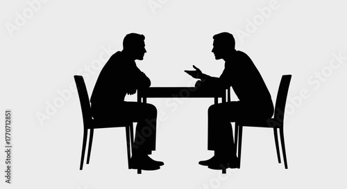 Silhouettes of two men sitting at a table, facing each other, engaged in a discussion or meeting