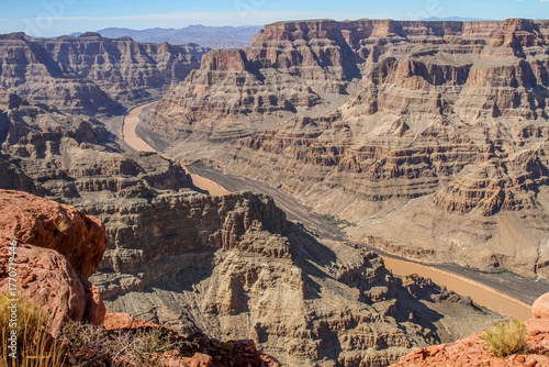 A panoramic view of the Grand Canyon with the Colorado River flowing through rocky cliffs in Arizona, USA. A stunning natural landscape, geological formation, and popular tourist destination.