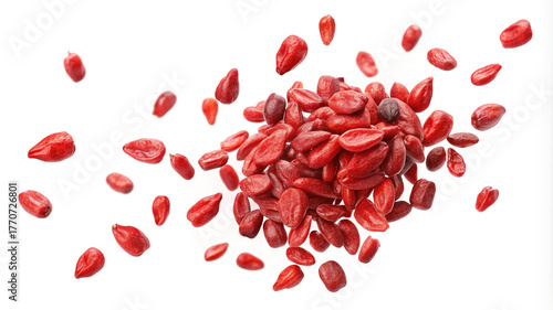 Scattered red barberry pieces in motion isolated against a white surface